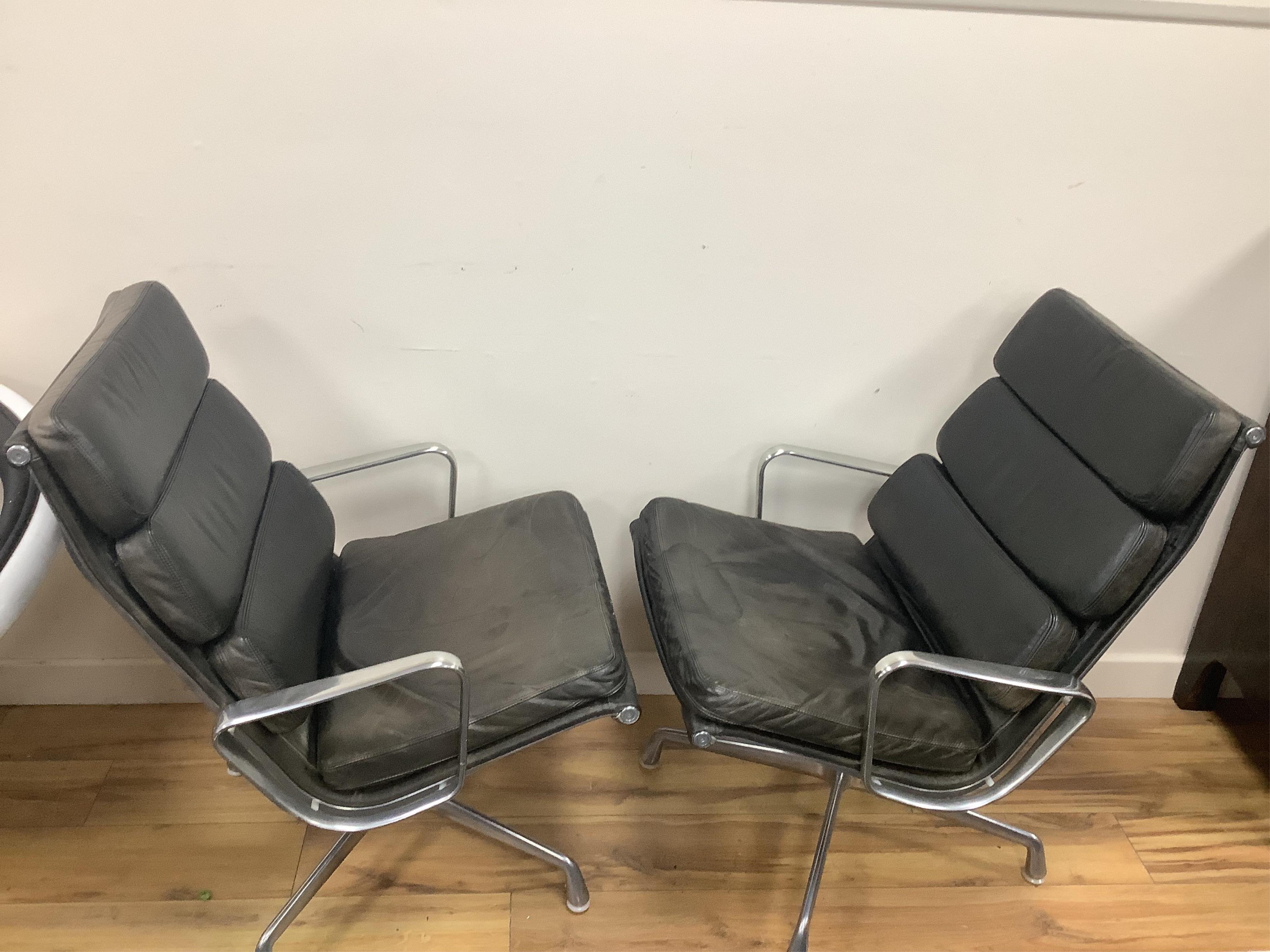 Charles and Ray Eames for Herman Miller, a pair of EA216 black leather and aluminium high back swivel armchairs, width 62cm, depth 69cm, height 87cm. Condition - fair